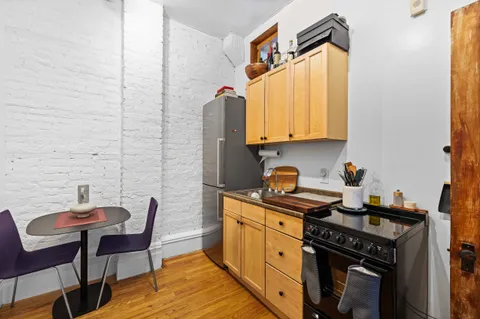 a kitchen with stainless steel appliances a stove a sink refrigerator and a chair