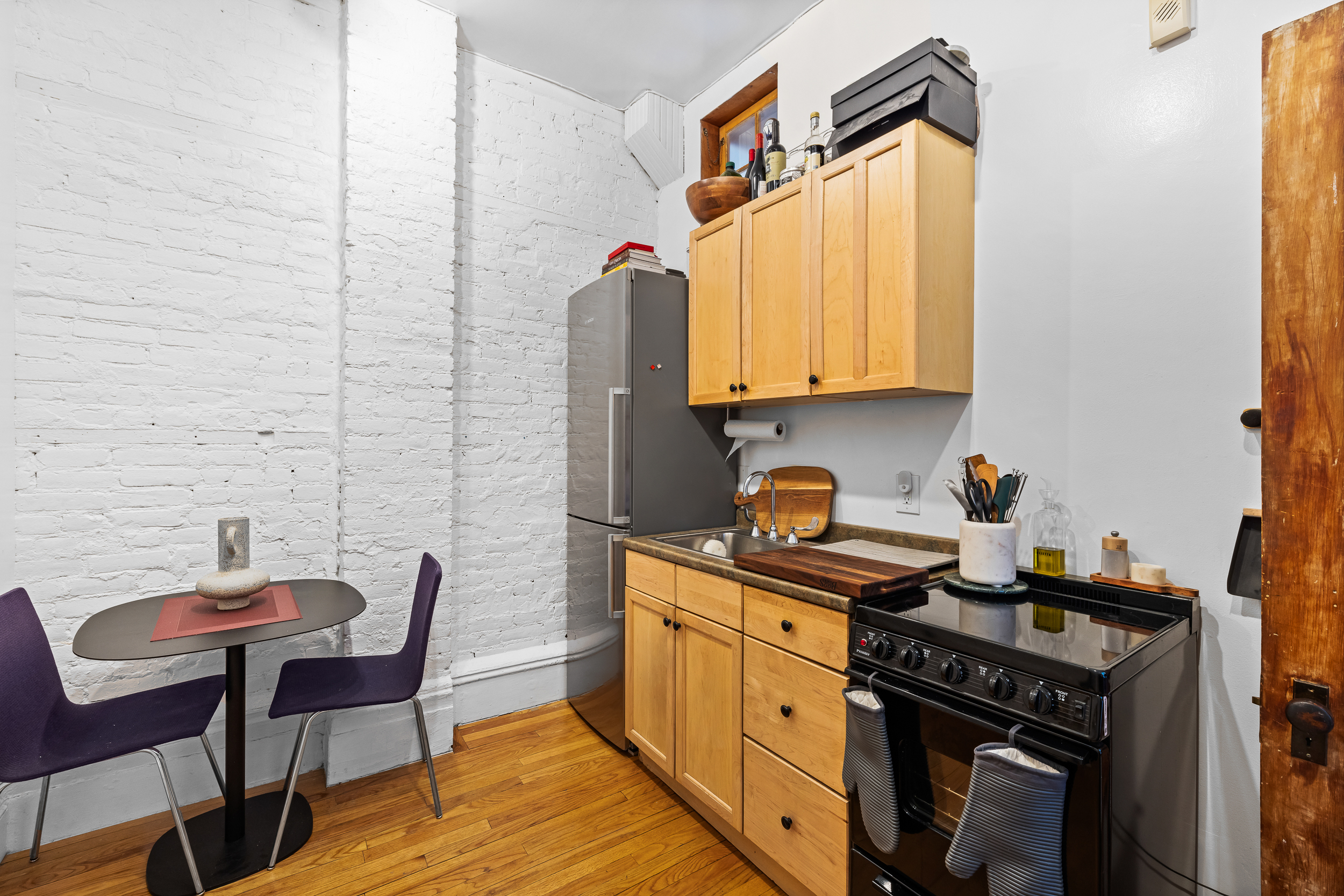 31 8th Avenue, Unit 1 Manhattan, NY 10014 - Photo 6 of 10 a kitchen with stainless steel appliances a stove a sink refrigerator and a chair