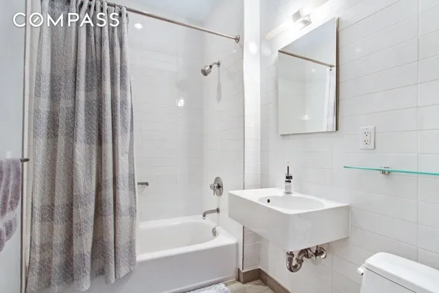 a white bath tub sitting next to a white sink and vanity