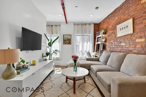 a living room with furniture a flat screen tv and a large window