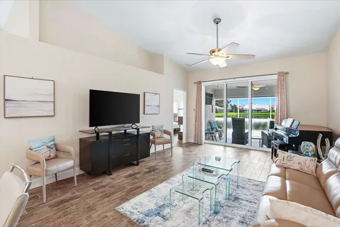 a living room with furniture a flat screen tv and a large window