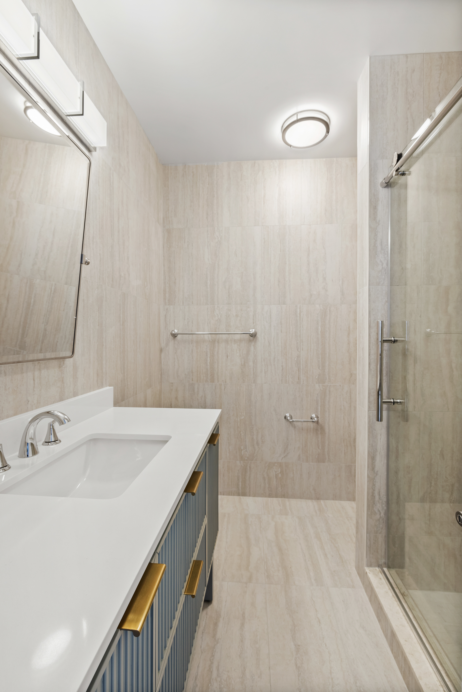 240 East 47th Street, Unit 27C Manhattan, NY 10017 - Photo 5 of 11 a bathroom with a sink a mirror and shower