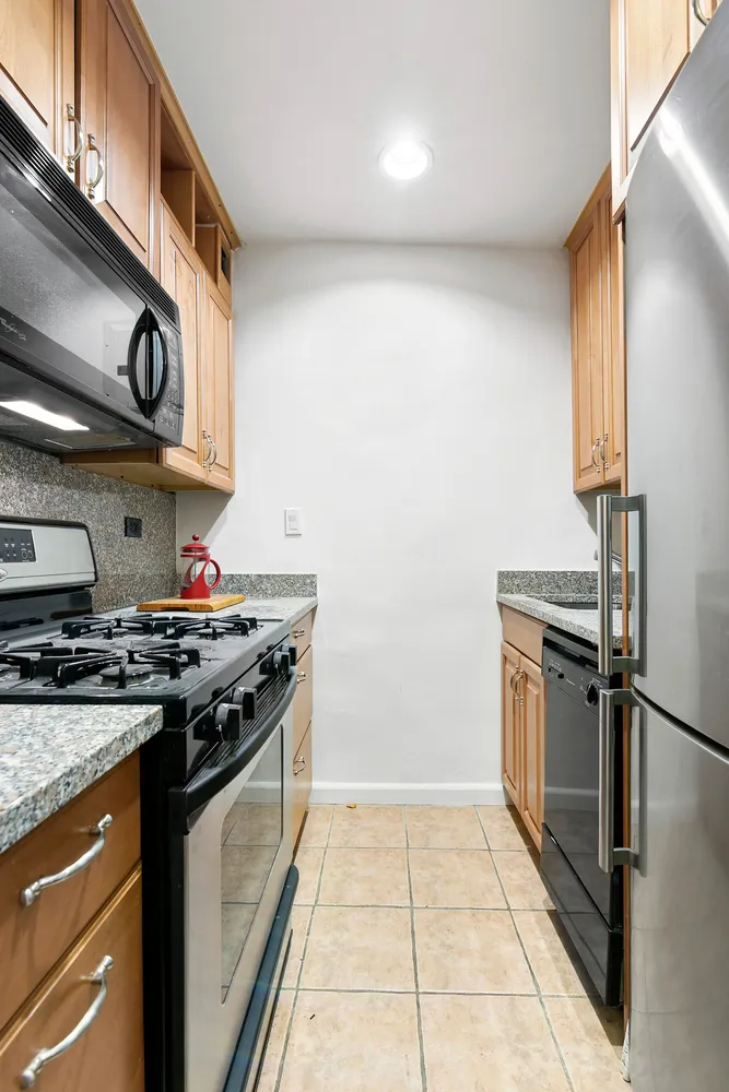 a kitchen with stainless steel appliances granite countertop a stove and a refrigerator