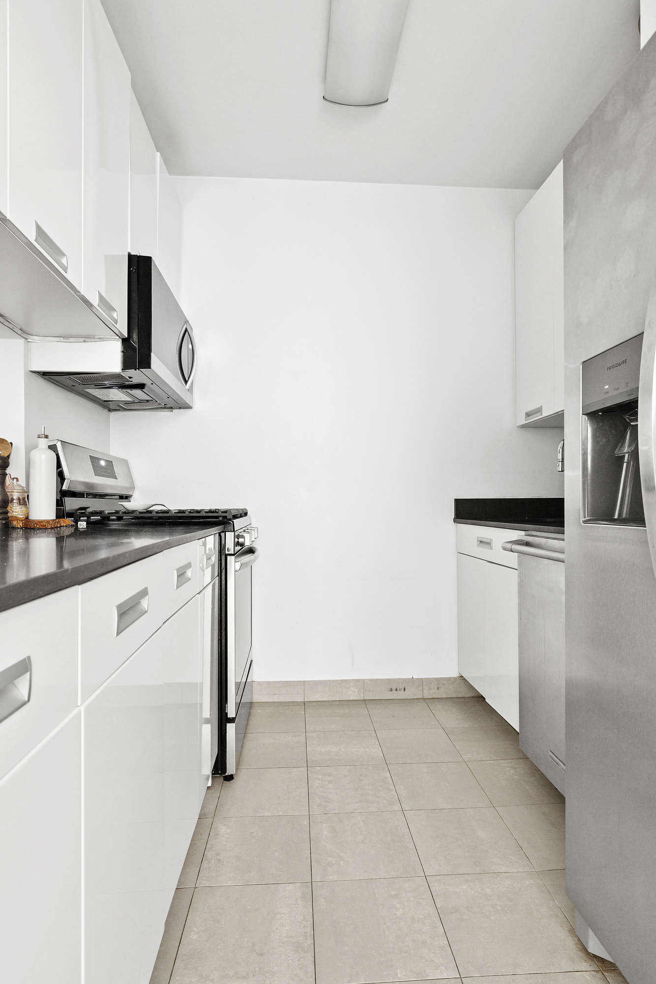 99 John Street, Unit 615 Manhattan, NY 10038 - Photo 2 of 6 a kitchen with a stove top oven and cabinets