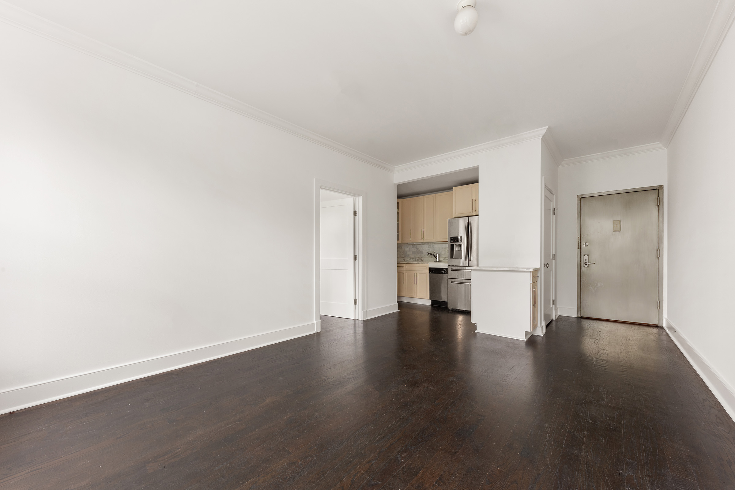 555 Lenox Avenue, Unit 3F Manhattan, NY 10030 - Photo 8 of 10 a view of empty room with wooden floor and kitchen