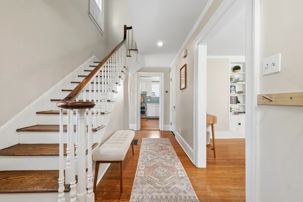 a view of a hallway with wooden floor and staircase