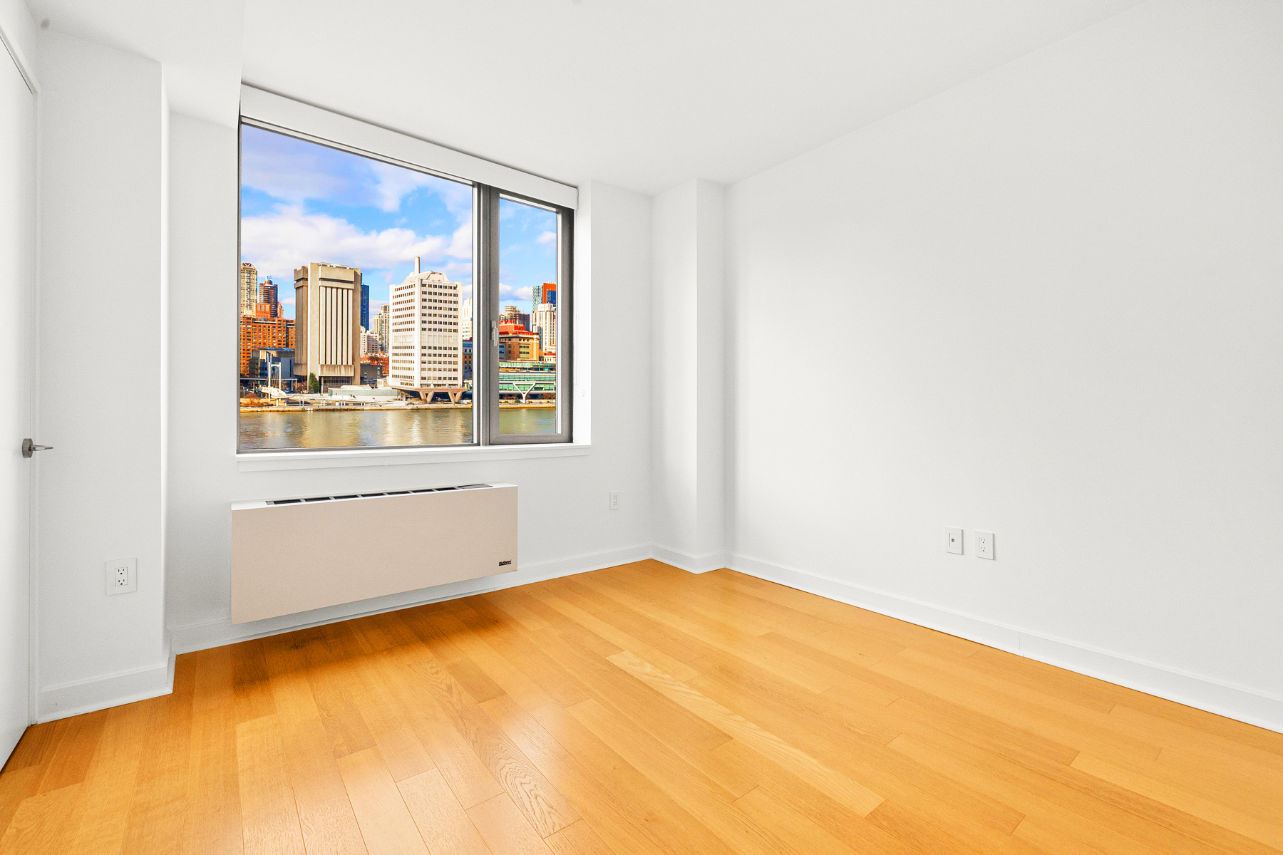 425 Main Street, Unit 9F Manhattan, NY 10044 - Photo 4 of 15 a view of an empty room with a window