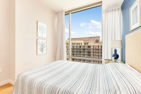 a large bed sitting in a bedroom next to a window