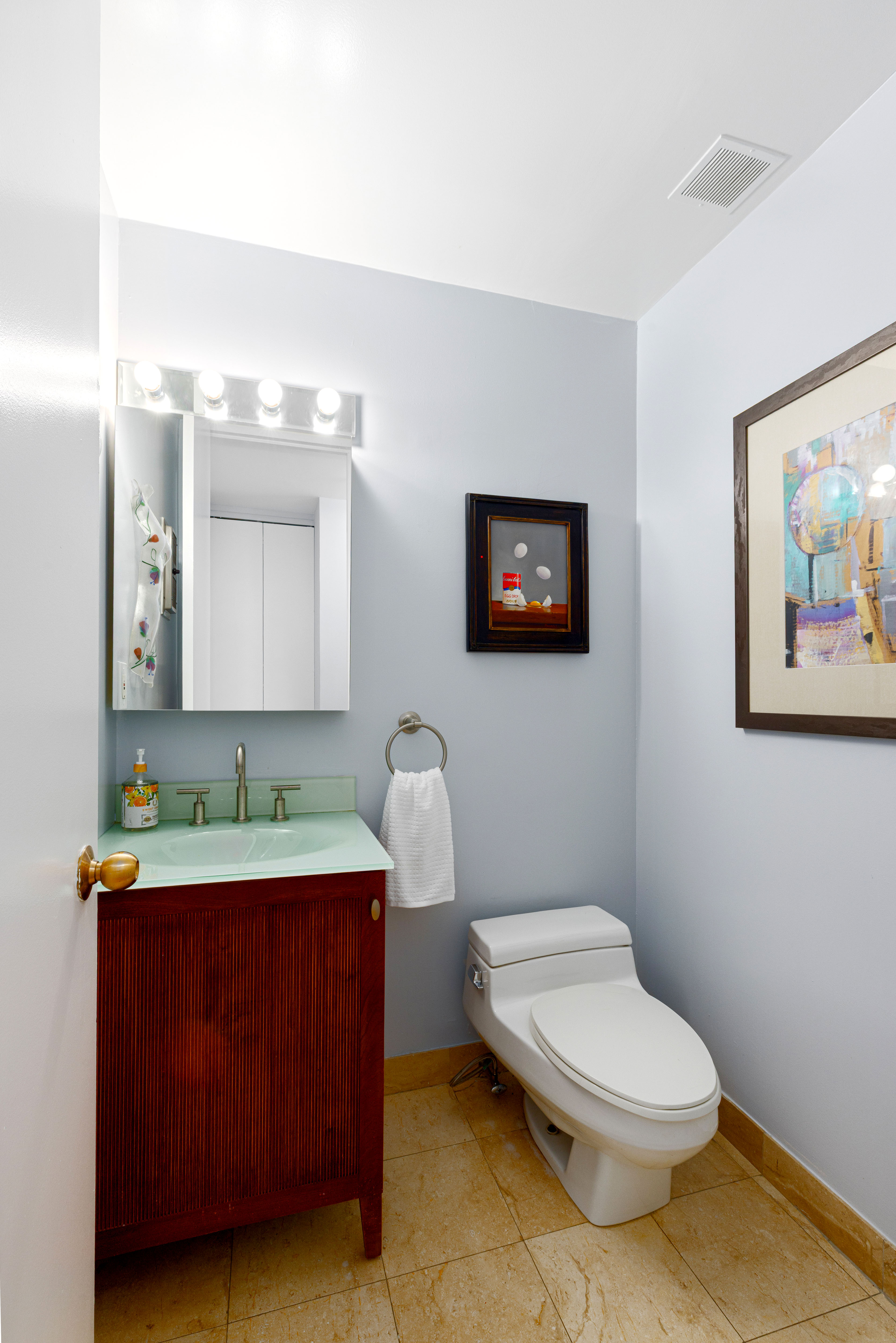 393 West 49th Street, Unit 5C Manhattan, NY 10019 - Photo 9 of 21 a bathroom with a toilet a sink and mirror