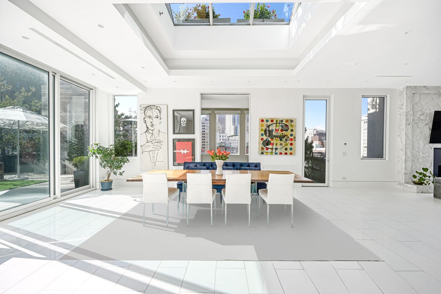 a living room with furniture a large window and potted plants