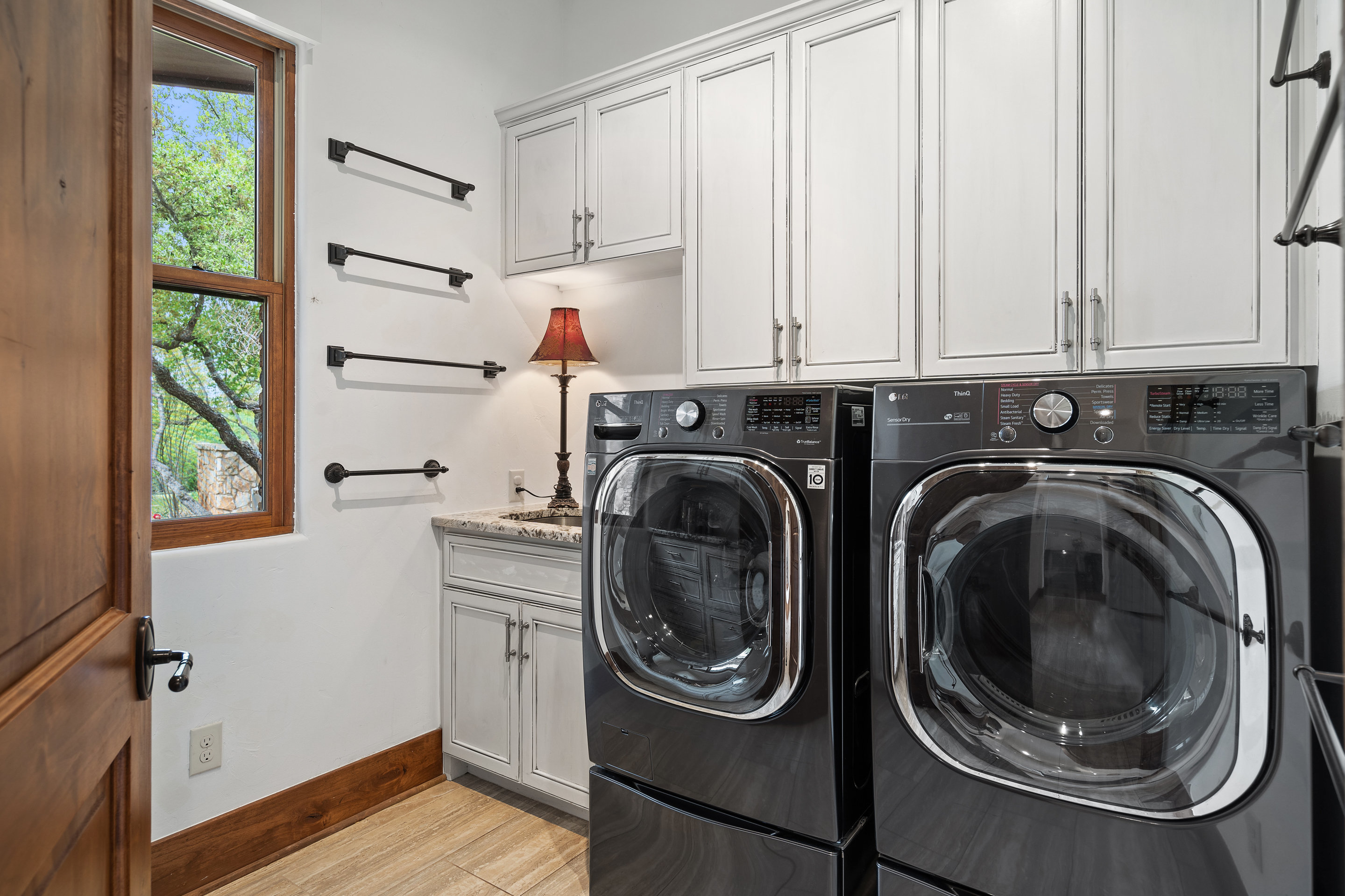 808 Rivercliff Drive Spicewood, TX 78669 - Photo 60 of 71 a utility room with sink dryer and washer