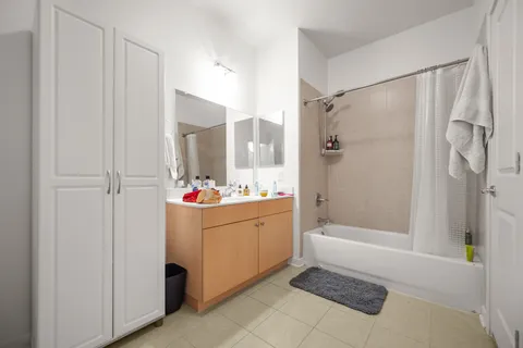 a bathroom with a tub sink shower and mirror