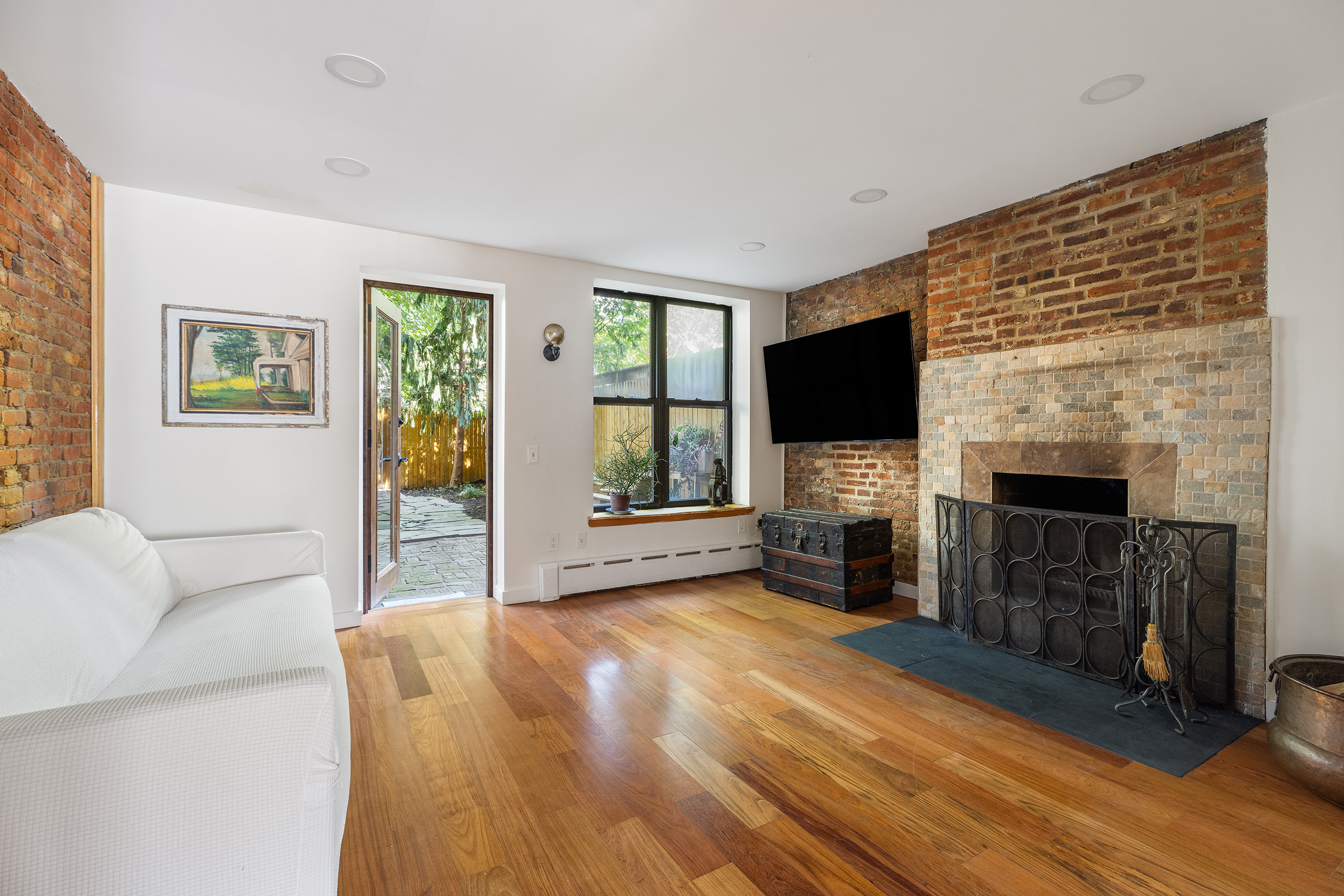 37 Quincy Street Brooklyn, NY 11238 - Photo 3 of 24 a living room with furniture a flat screen tv and a fireplace