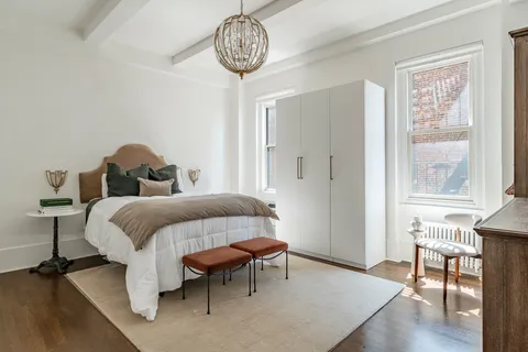 a bedroom with a bed and a table in it next to a window