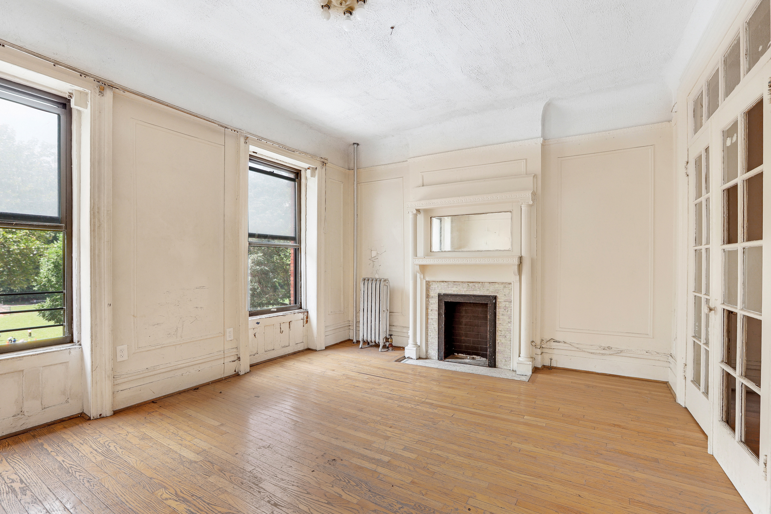 282 Manhattan Avenue, Unit 3N Manhattan, NY 10026 - Photo 4 of 17 an empty room with wooden floor fireplace and windows