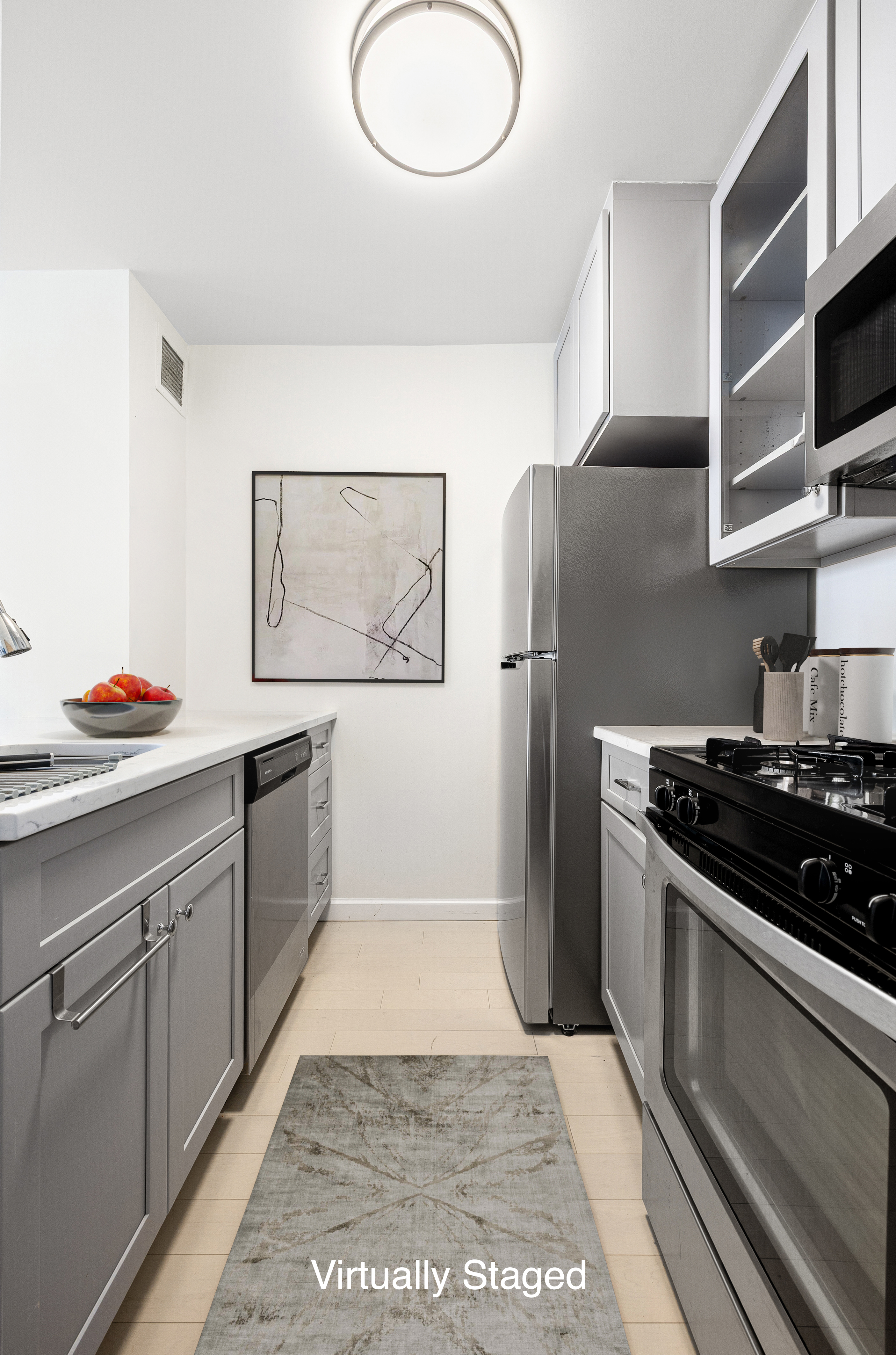 61 West 62nd Street, Unit 17L Manhattan, NY 10023 - Photo 4 of 10 a kitchen with stainless steel appliances granite countertop a refrigerator and a stove