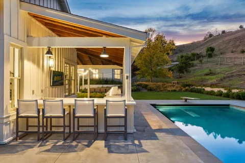 a view of a patio with a table chairs and a swimming pool
