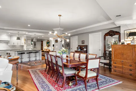 a dining room with furniture a rug and a kitchen