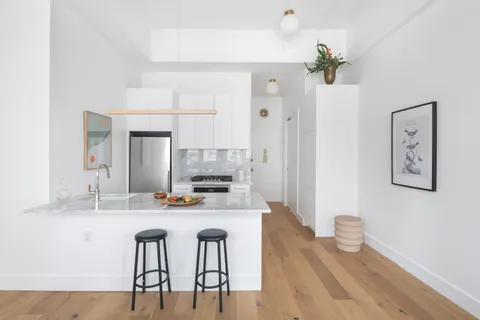 a kitchen with stainless steel appliances a dining table chairs and chandelier