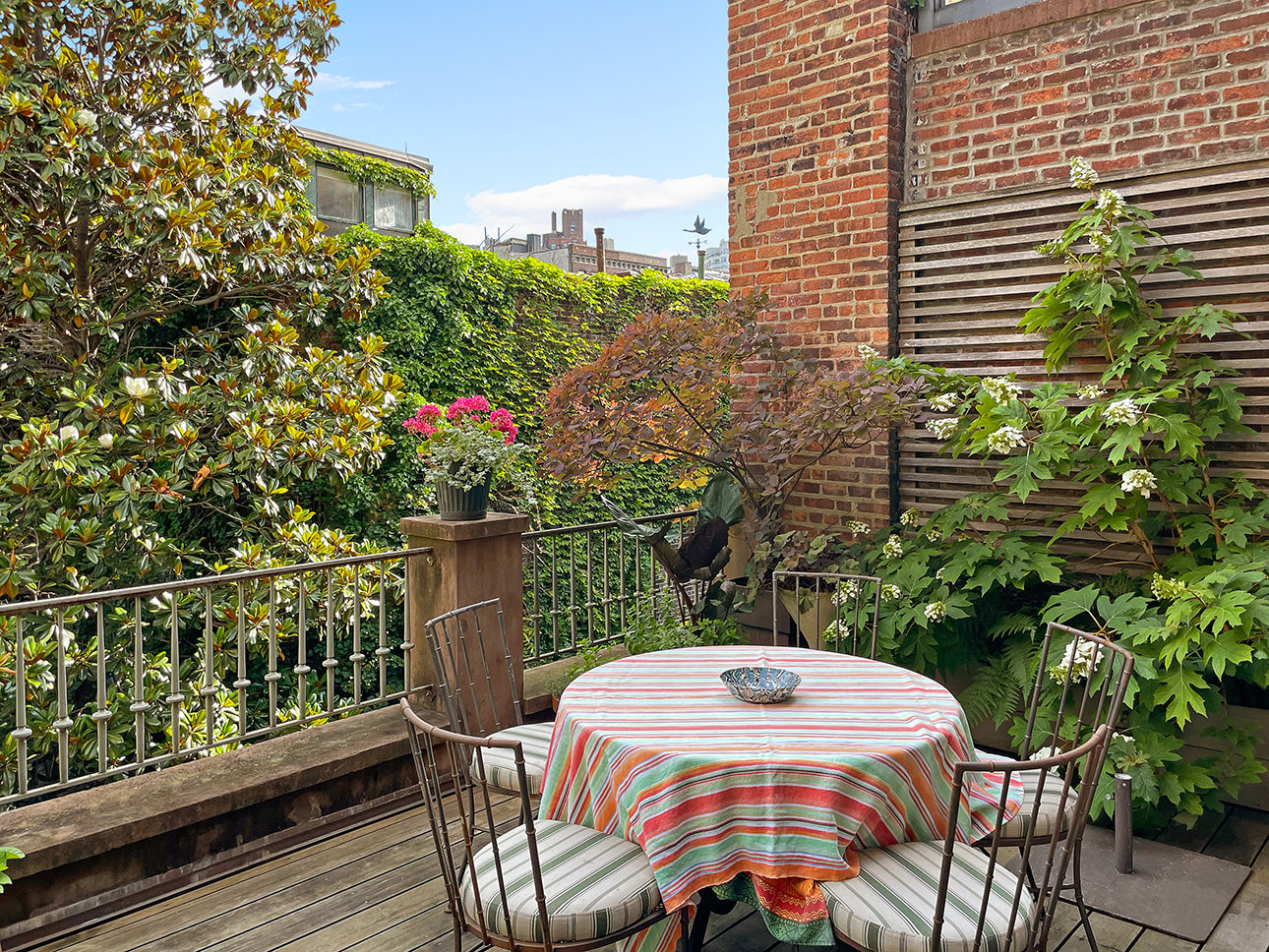 25 Perry Street Manhattan, NY 10014 - Photo 19 of 32 a view of a balcony with table and chairs and wooden fence