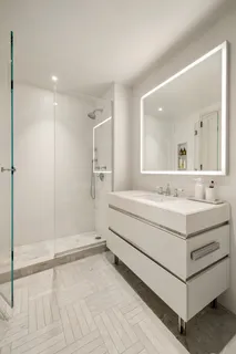 a bathroom with a bathtub a mirror and a shower