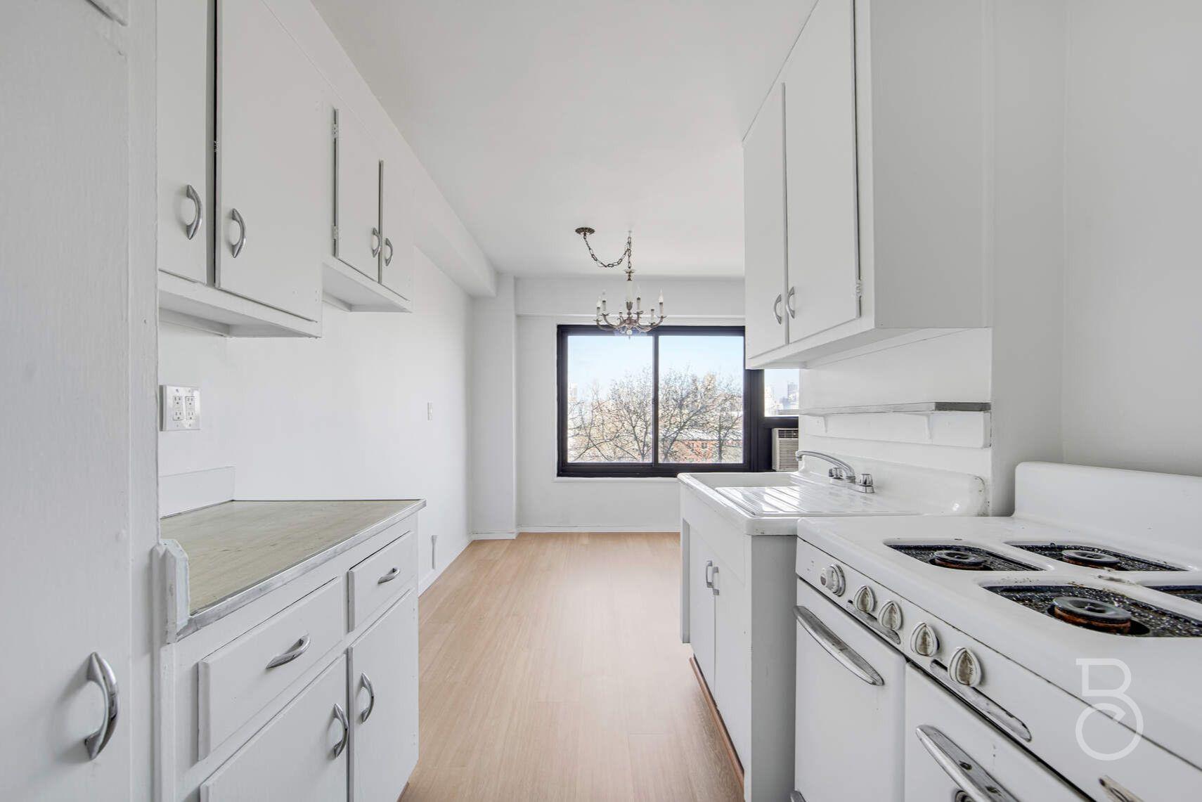 33-65 14th Street, Unit 5D Queens, NY 11106 - Photo 6 of 11 a kitchen with granite countertop a sink stove and refrigerator