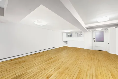a view of empty room with wooden floor