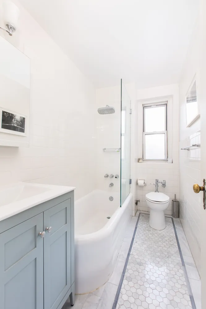 a bathroom with a white tub sitting next to a white sink and vanity