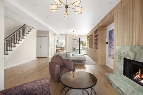a living room with furniture a fireplace and a chandelier
