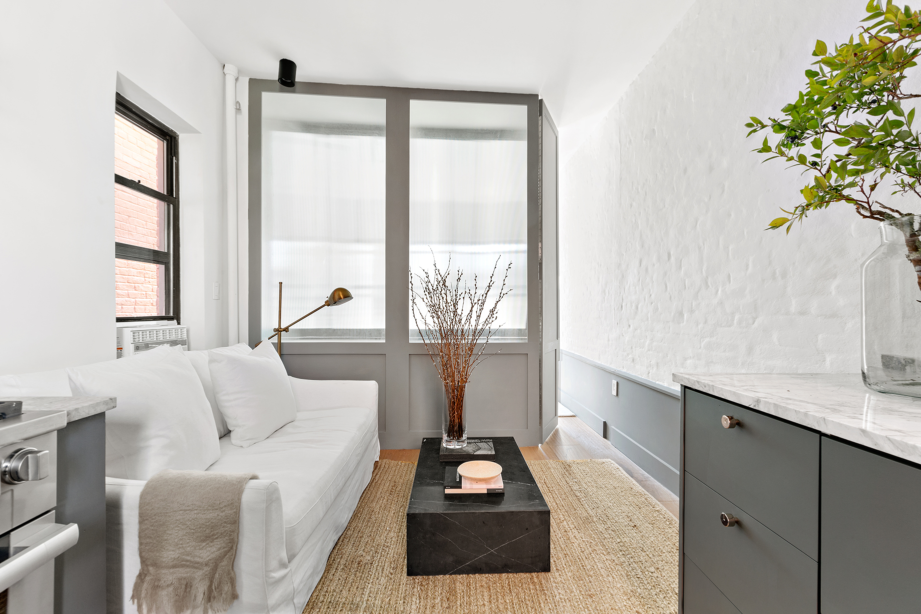 110 Thompson Street, Unit 6E Manhattan, NY 10012 - Photo 6 of 8 a living room with furniture and a large window