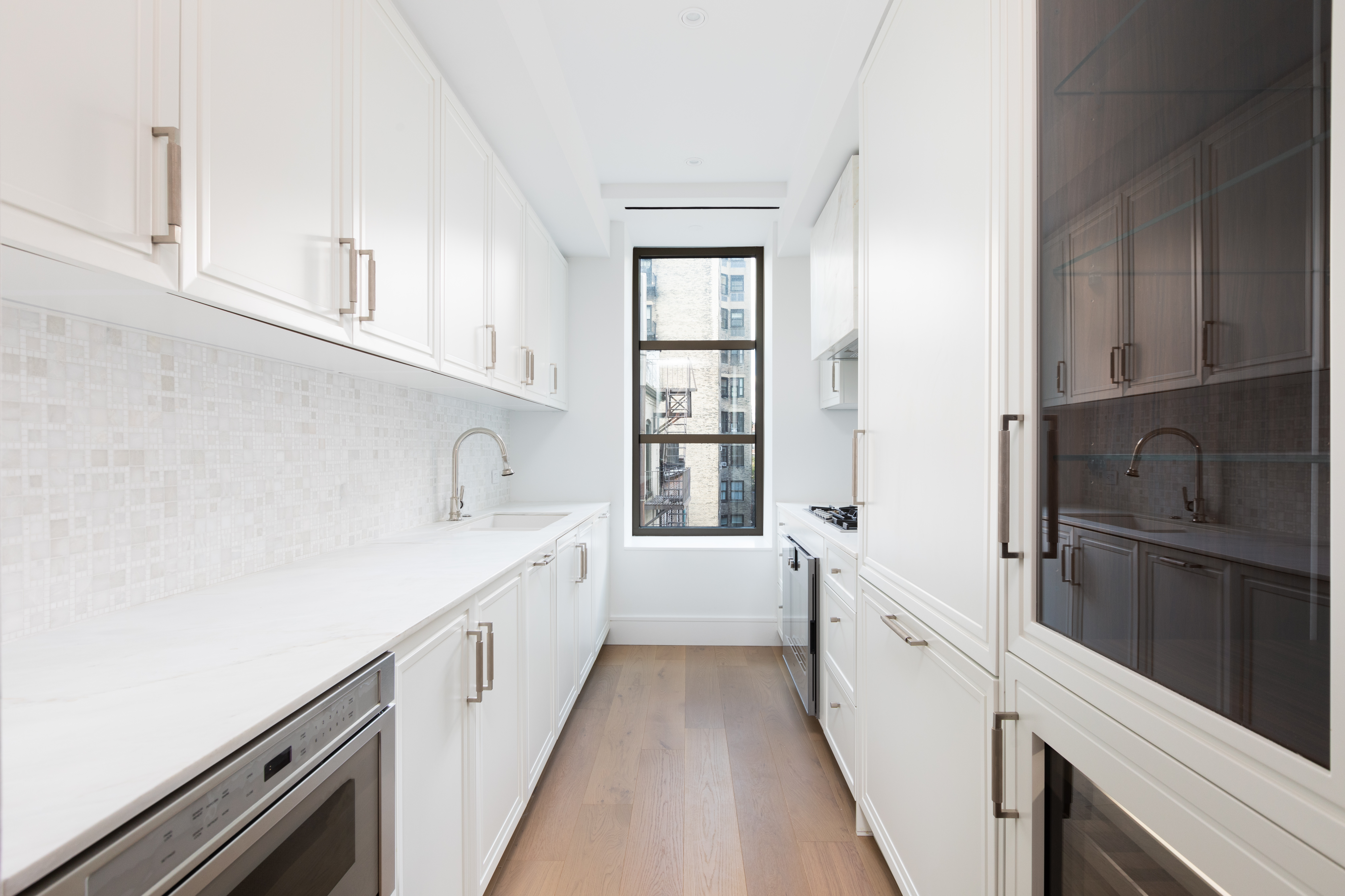 251 West 91st Street, Unit 5B Manhattan, NY 10024 - Photo 3 of 17 a kitchen with white cabinets and white appliances