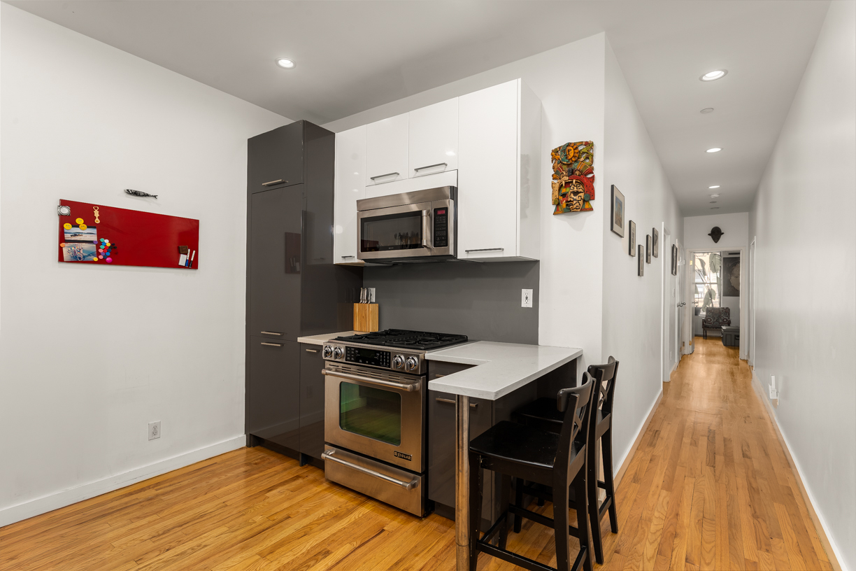 119 East 101st Street, Unit 1A Manhattan, NY 10029 - Photo 4 of 10 a kitchen with stainless steel appliances a stove a microwave a sink and a refrigerator