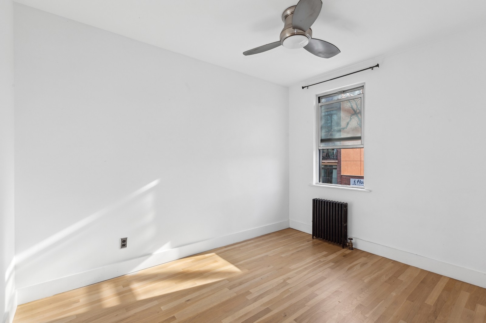 209 Frost Street, Unit 2 Brooklyn, NY 11211 - Photo 5 of 8 a view of empty room with wooden floor and fan