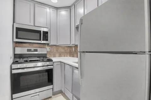 a kitchen with stainless steel appliances white cabinets and a stove