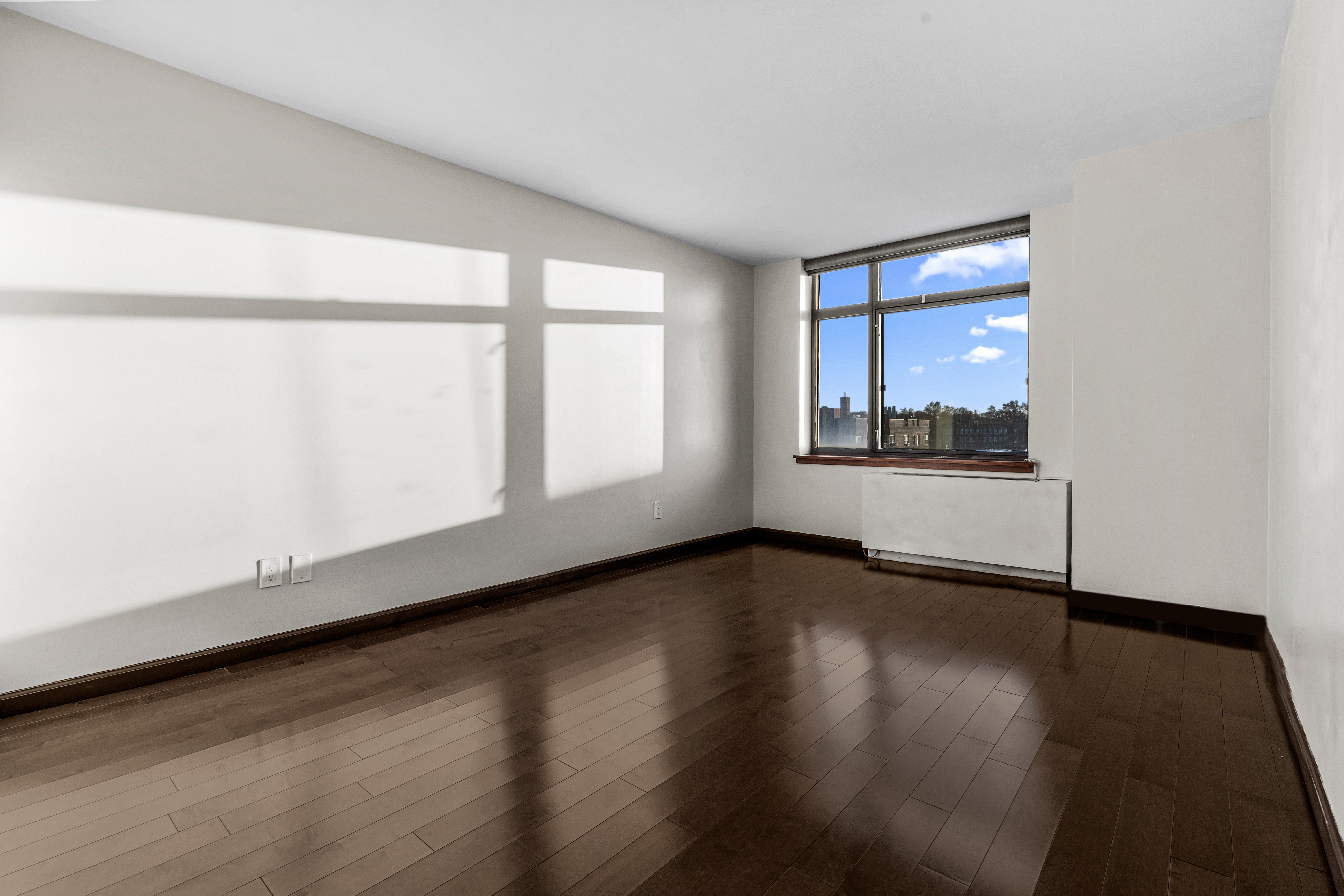 112-01 Queens Boulevard, Unit 7E Queens, NY 11375 - Photo 14 of 27 a view of an empty room with wooden floor and a window