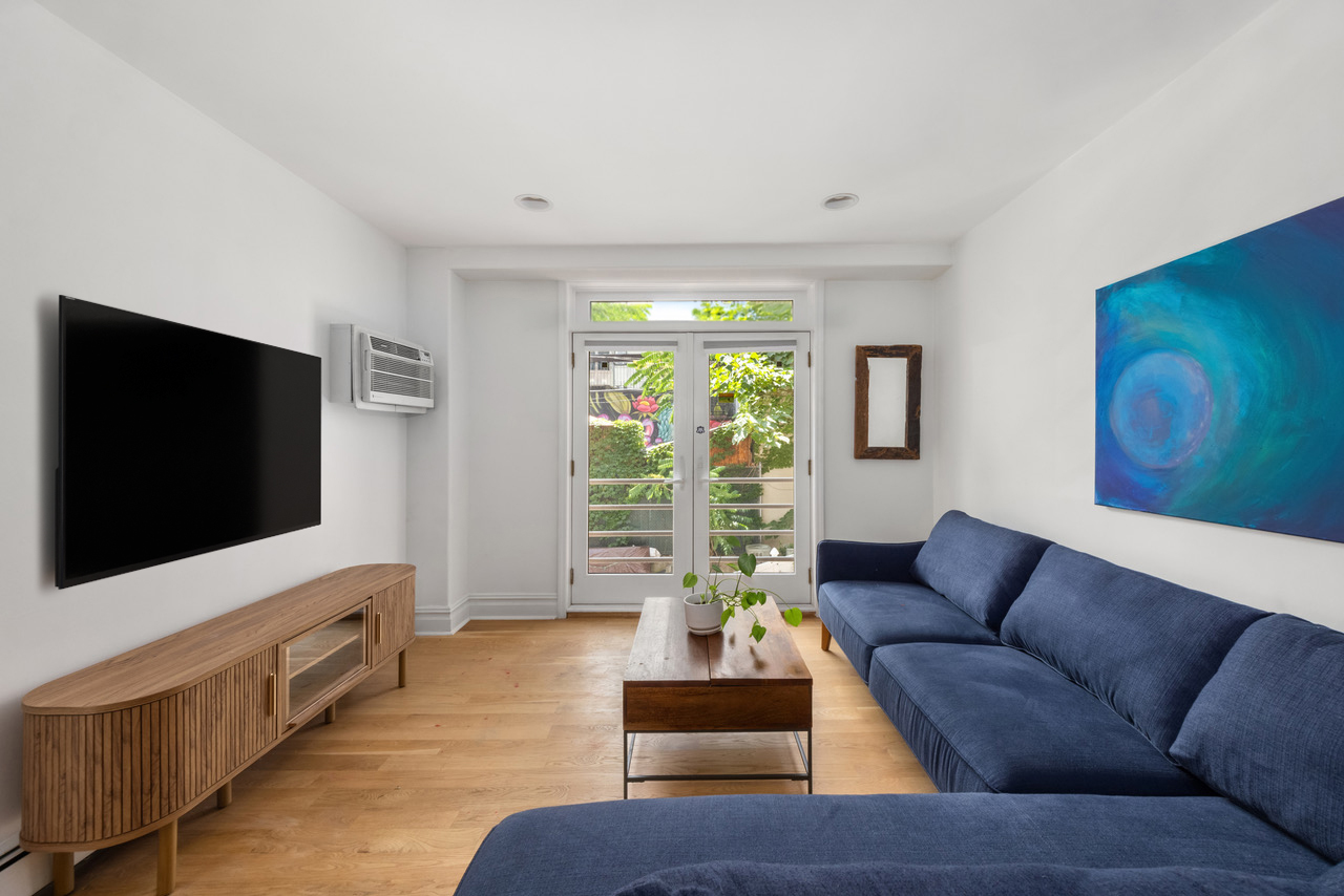 150 South 1st Street, Unit 2K Brooklyn, NY 11211 - Photo 2 of 12 a living room with furniture and a flat screen tv