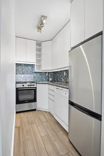 a kitchen with granite countertop a refrigerator stove and sink