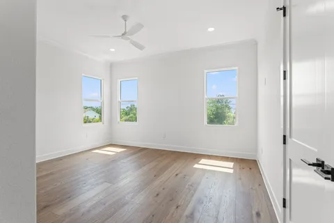 an empty room with wooden floor and windows
