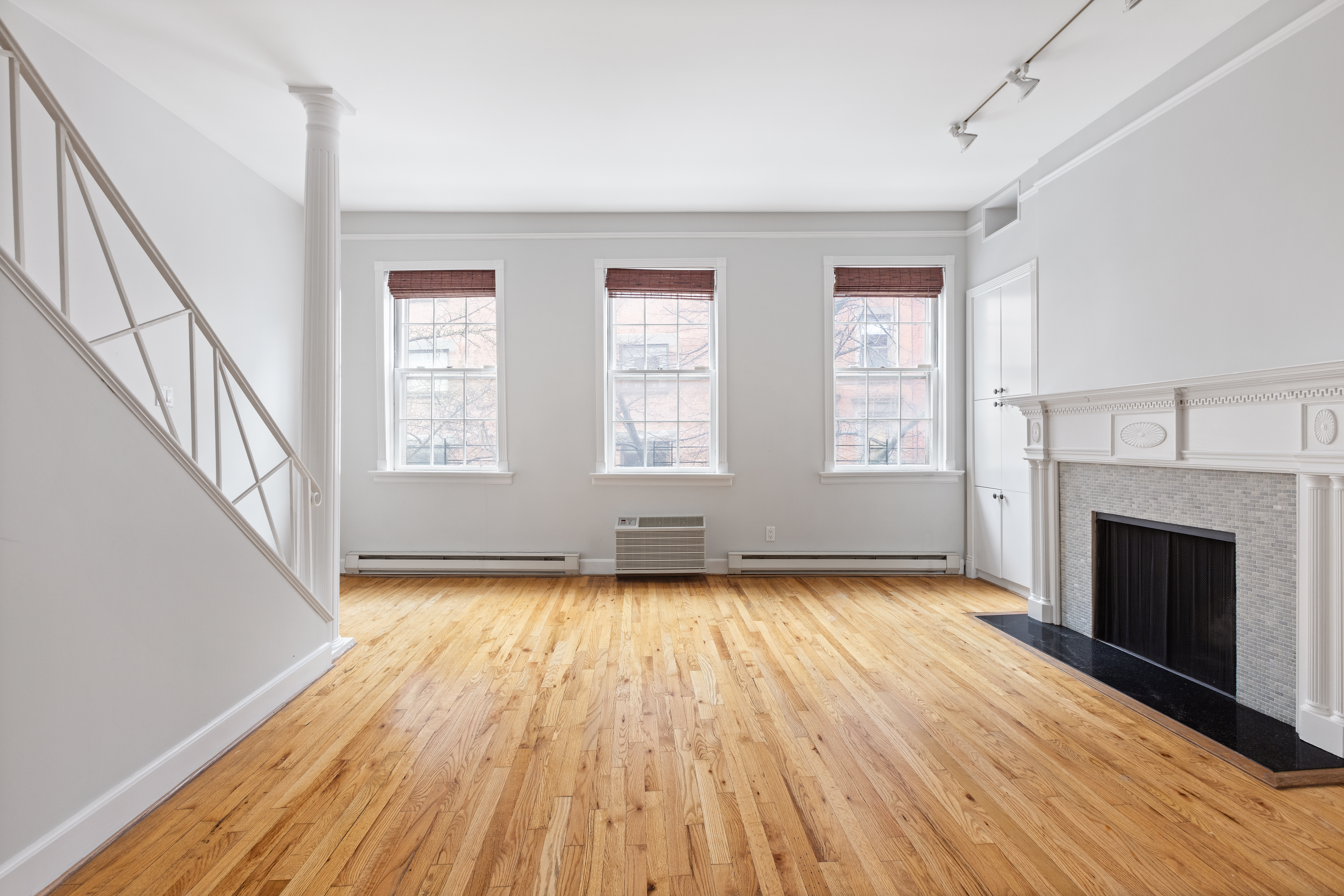 10 Bedford Street Manhattan, NY 10014 - Photo 4 of 29 a view of an empty room with wooden floor fireplace and a window