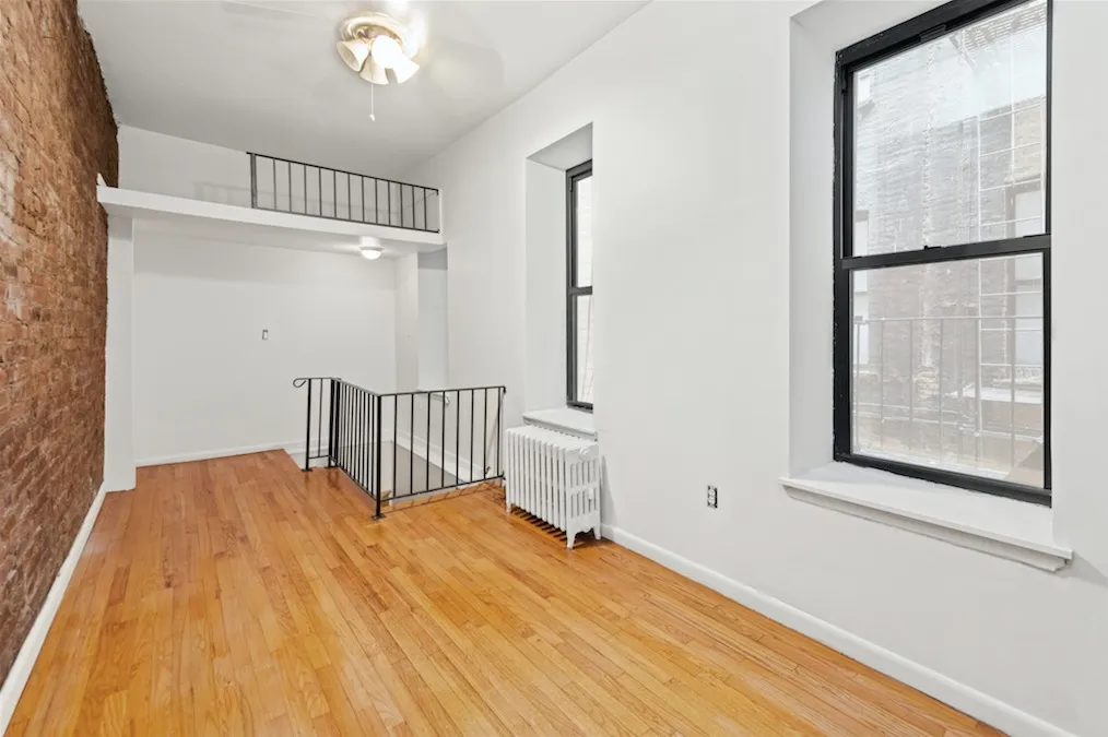 a view of a room with wooden floor and windows