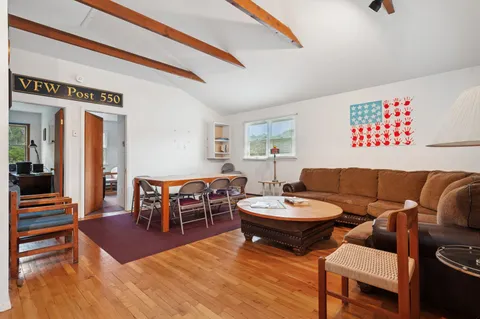 a living room with furniture a rug and a window