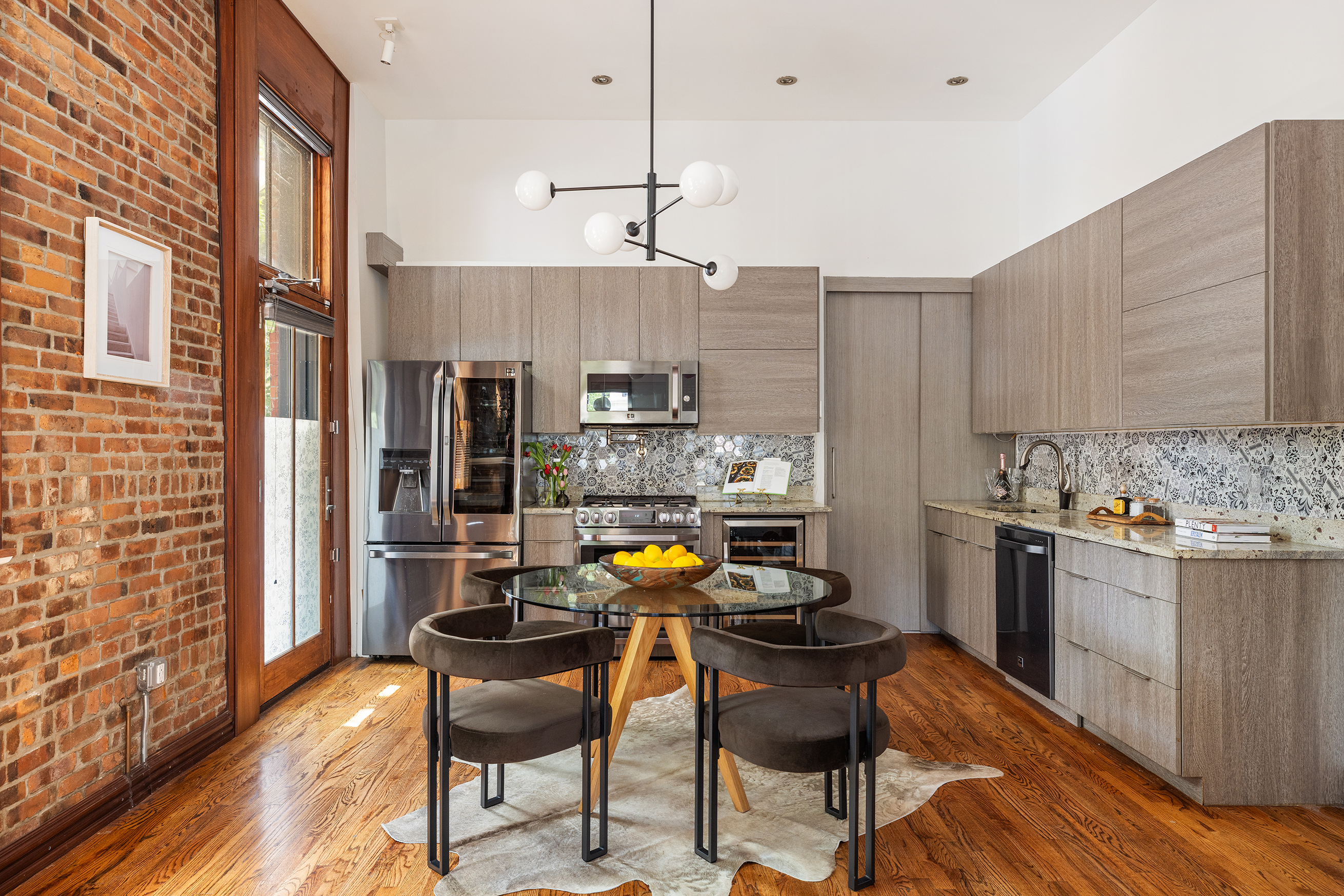 412 Classon Avenue Brooklyn, NY 11238 - Photo 5 of 30 a kitchen with stainless steel appliances kitchen island granite countertop a table chairs in it and wooden floors