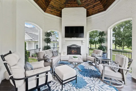 a living room with furniture a fireplace and a flat screen tv