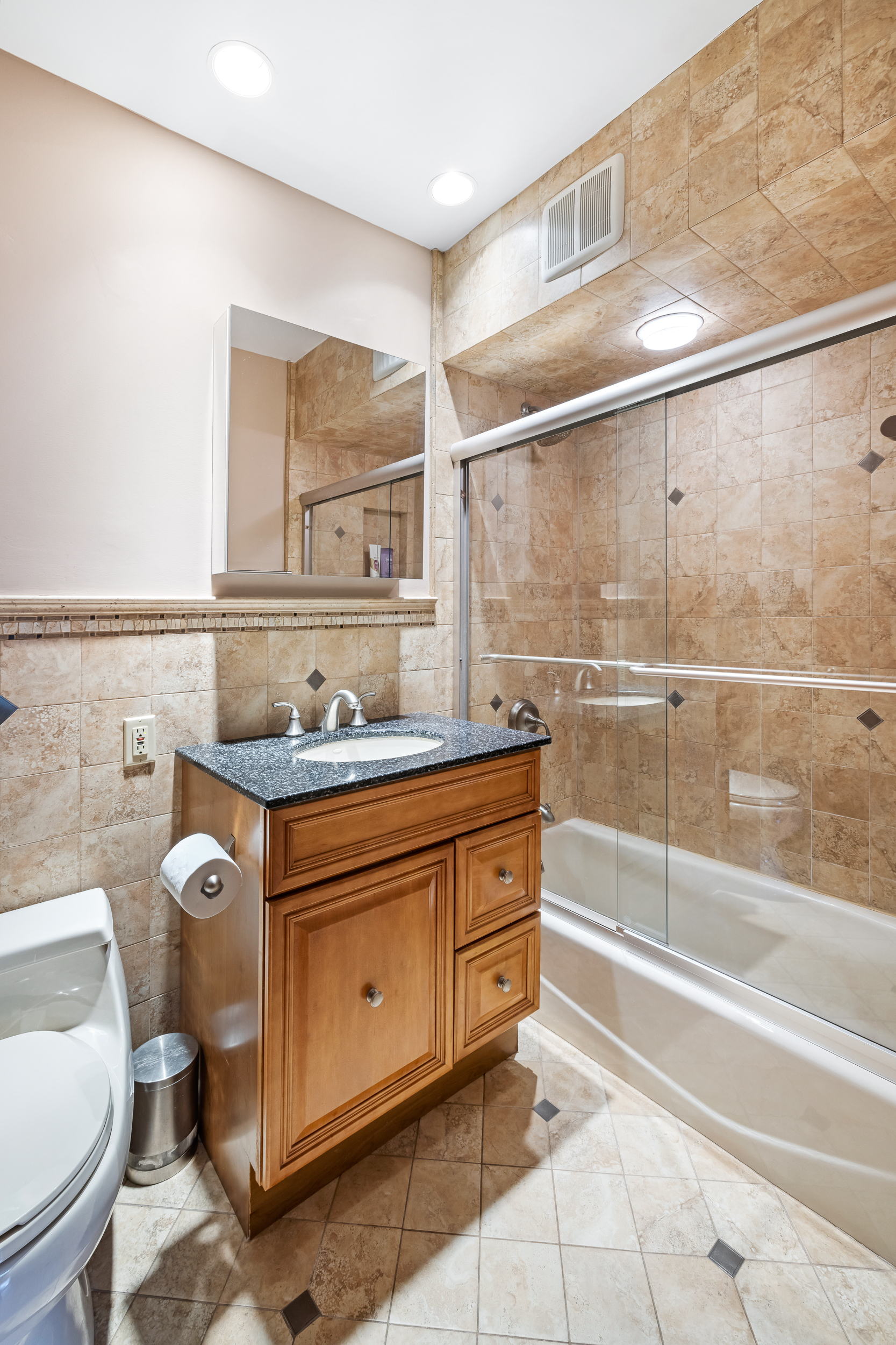 436 78th Street, Unit 5 Brooklyn, NY 11209 - Photo 9 of 10 a bathroom with a granite countertop sink a toilet a mirror and shower