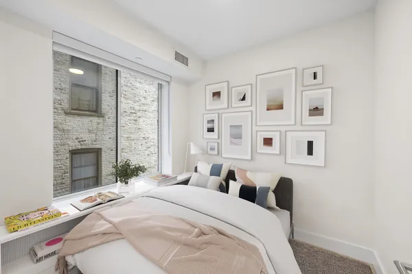a bedroom with a bed and a window