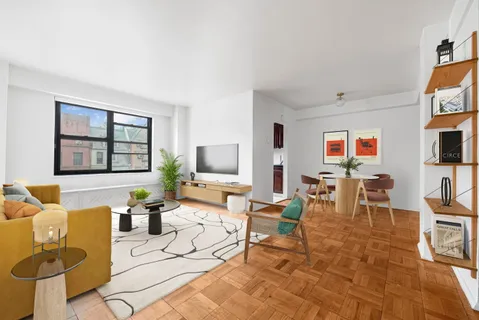 a living room with furniture a flat screen tv and a window