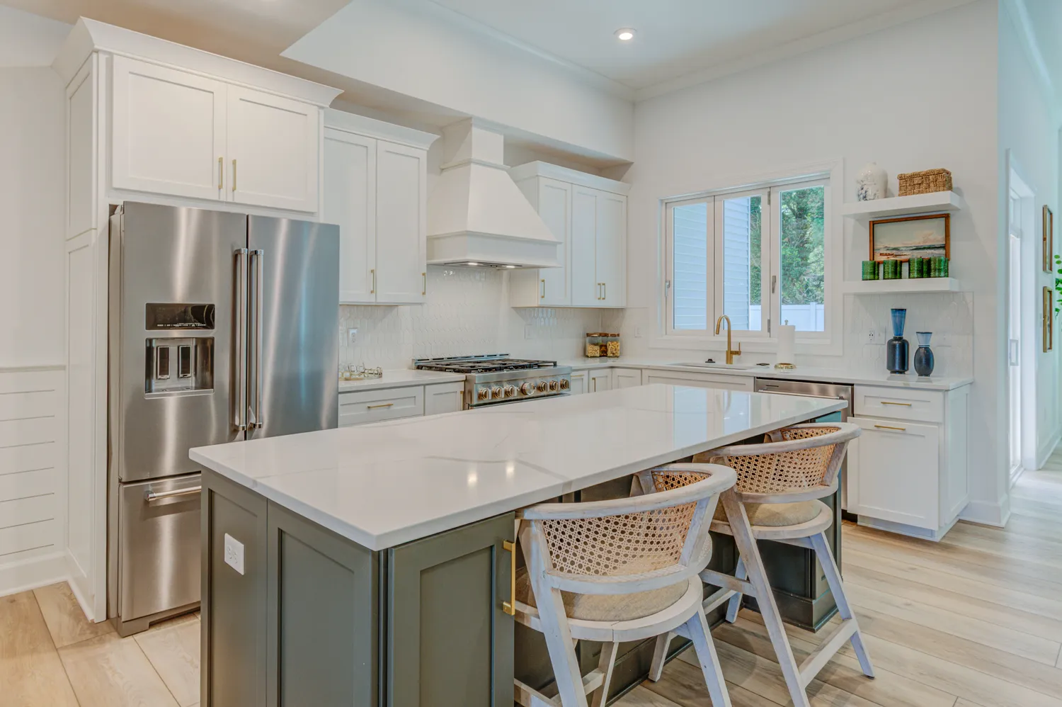 a kitchen with granite countertop a table chairs stainless steel appliances and window