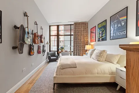 a bedroom with a bed and a large mirror next to a window