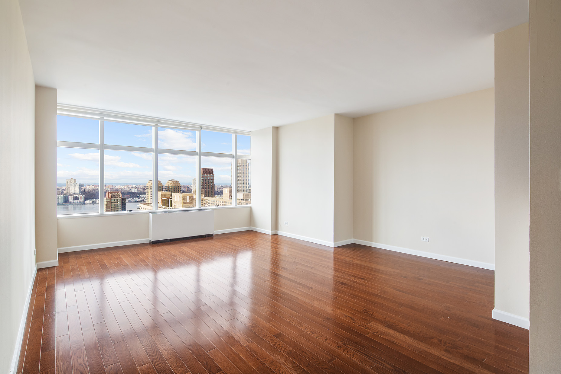 160 West 66th Street, Unit 33A Manhattan, NY 10023 - Photo 5 of 11 a view of an empty room with wooden floor and a window