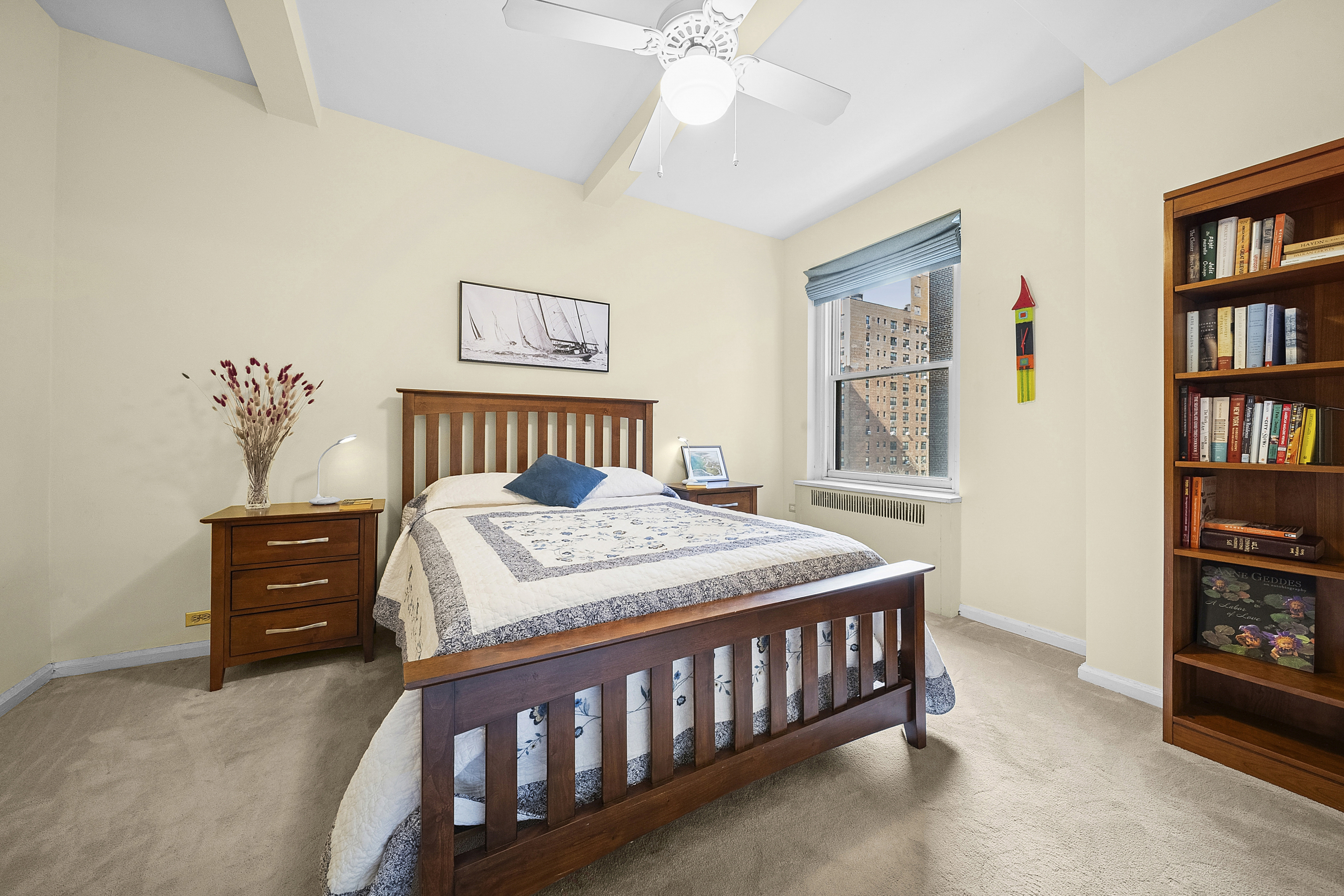 263 West End Avenue, Unit 9E Manhattan, NY 10023 - Photo 4 of 10 a bedroom with a bed and a book shelf
